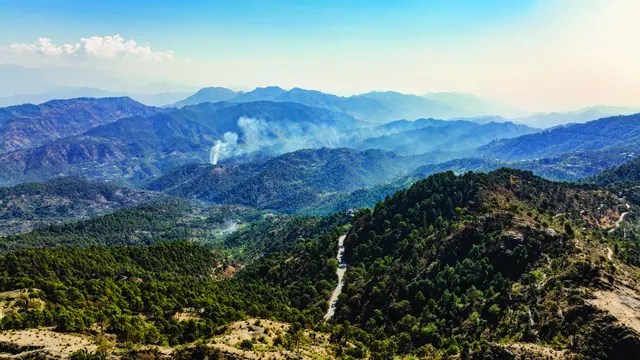 Real drone photograph of the forested Sirmaur valley and hill road